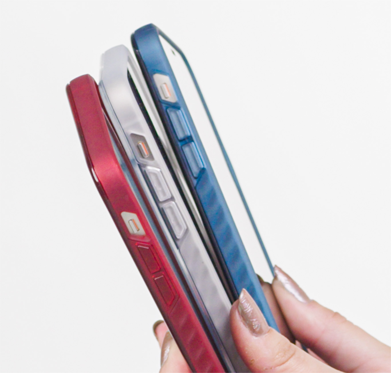 A person holding 3 iPhones with red, white, and blue Bravo cases.